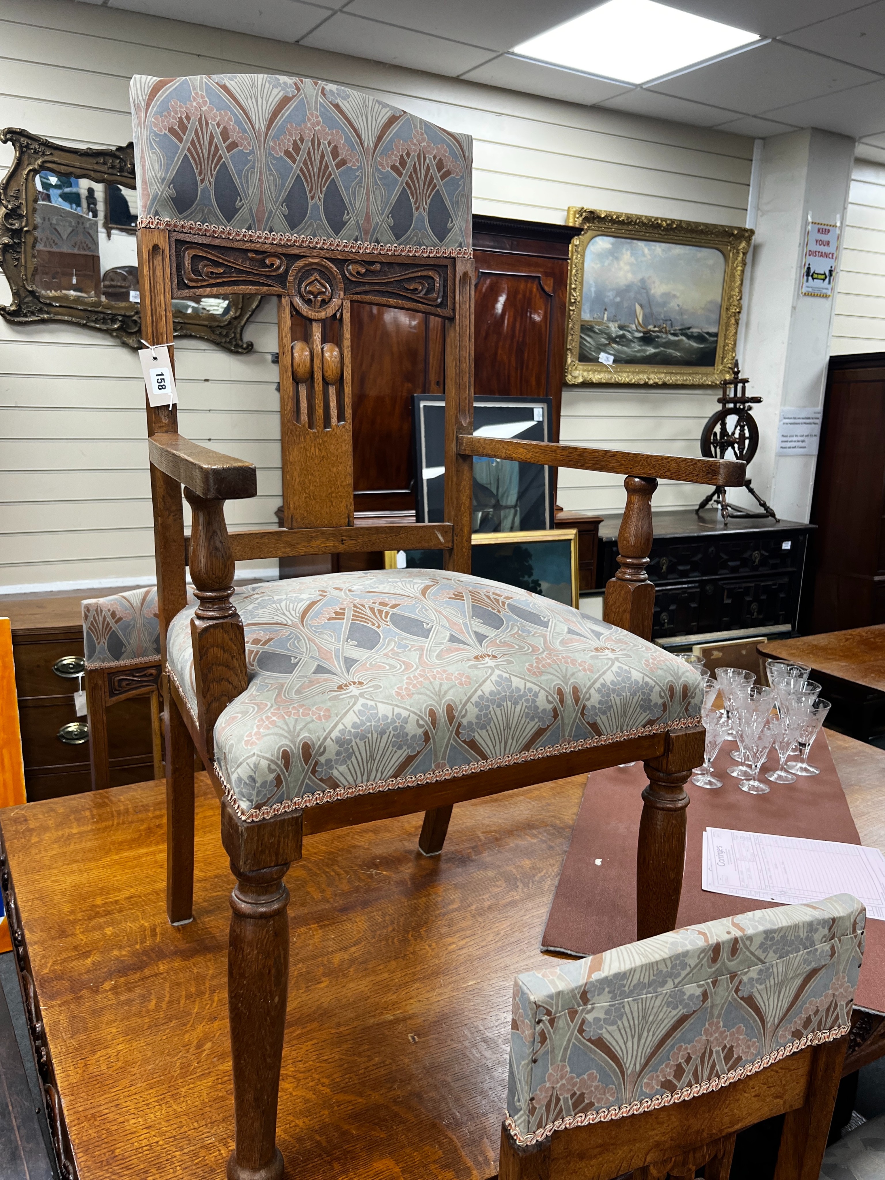 A set of Art Nouveau carved oak dining chairs, one with arms with original Liberty receipt